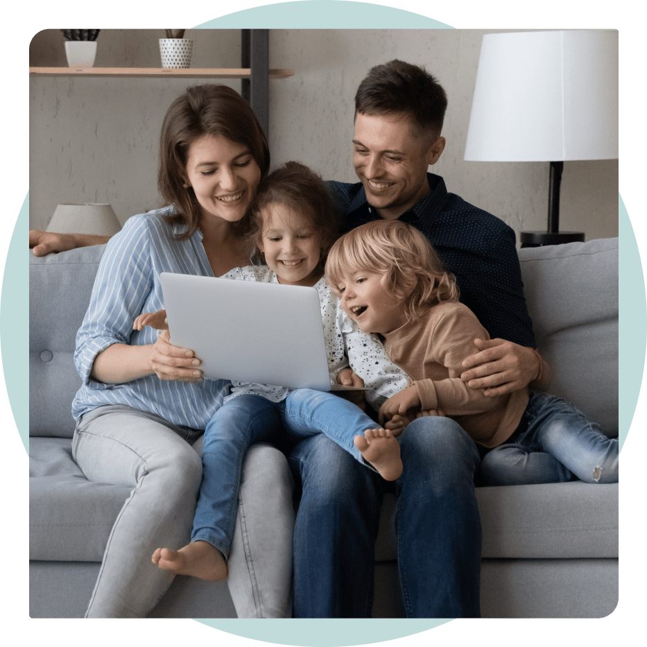Family looking at laptop on from their couch